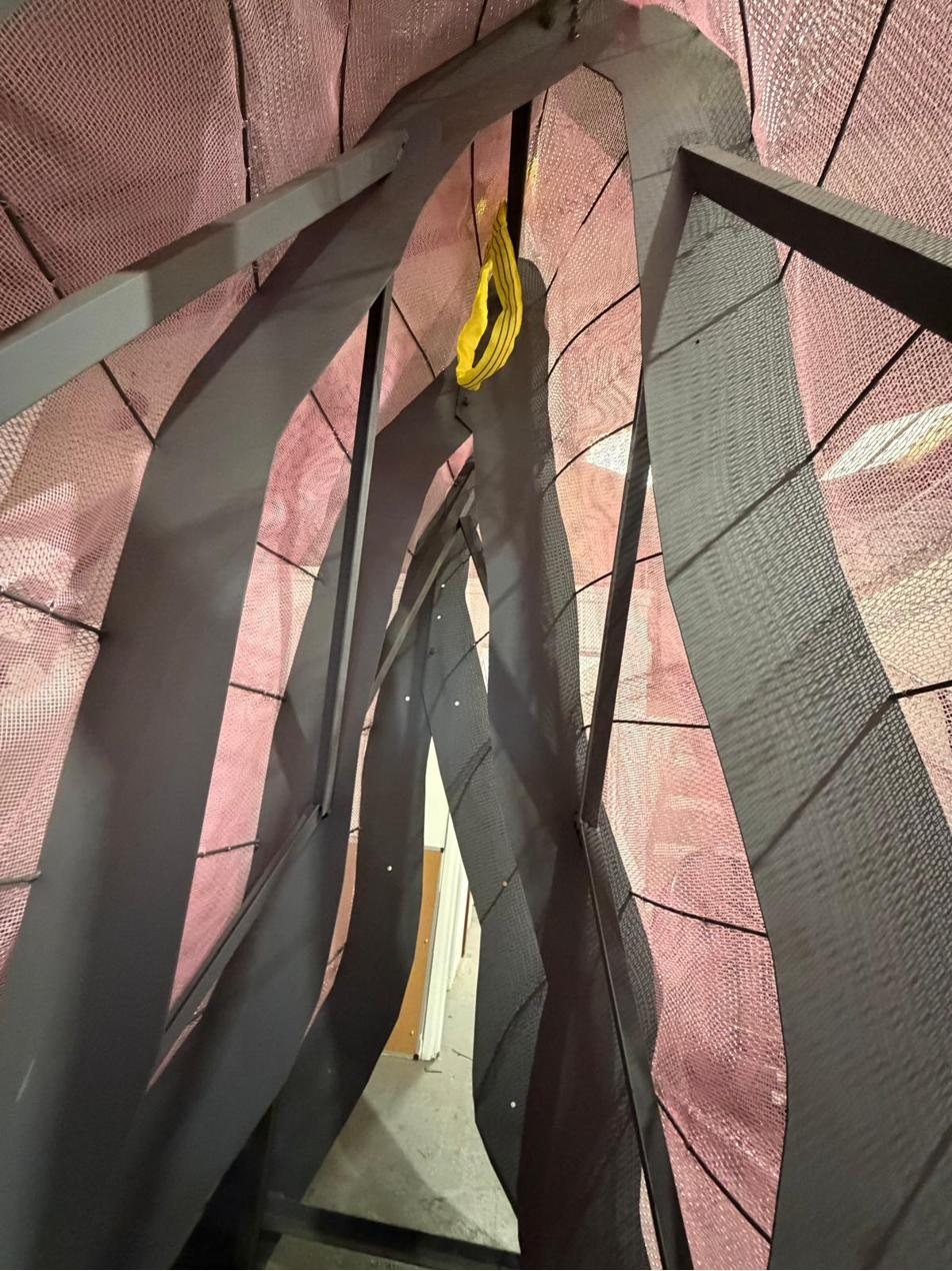 Looking up through the steel ribs into the pink scrim mesh skin