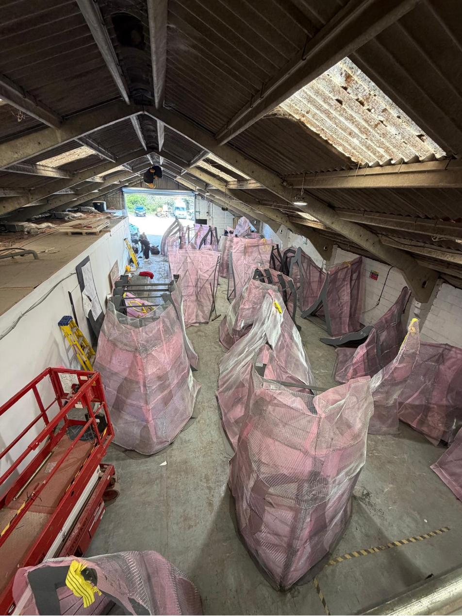 Scrim-wrapped forms stored together in the workshop before transport