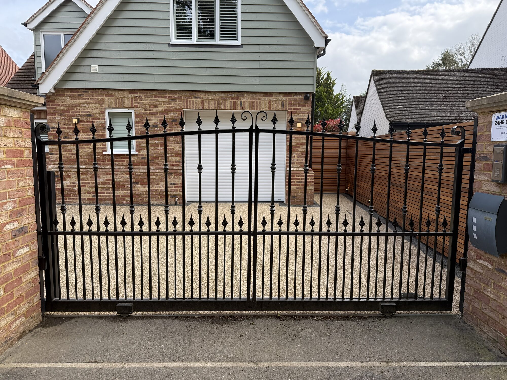 Wall-mounted iron gate with diamond finials and turned bar detail