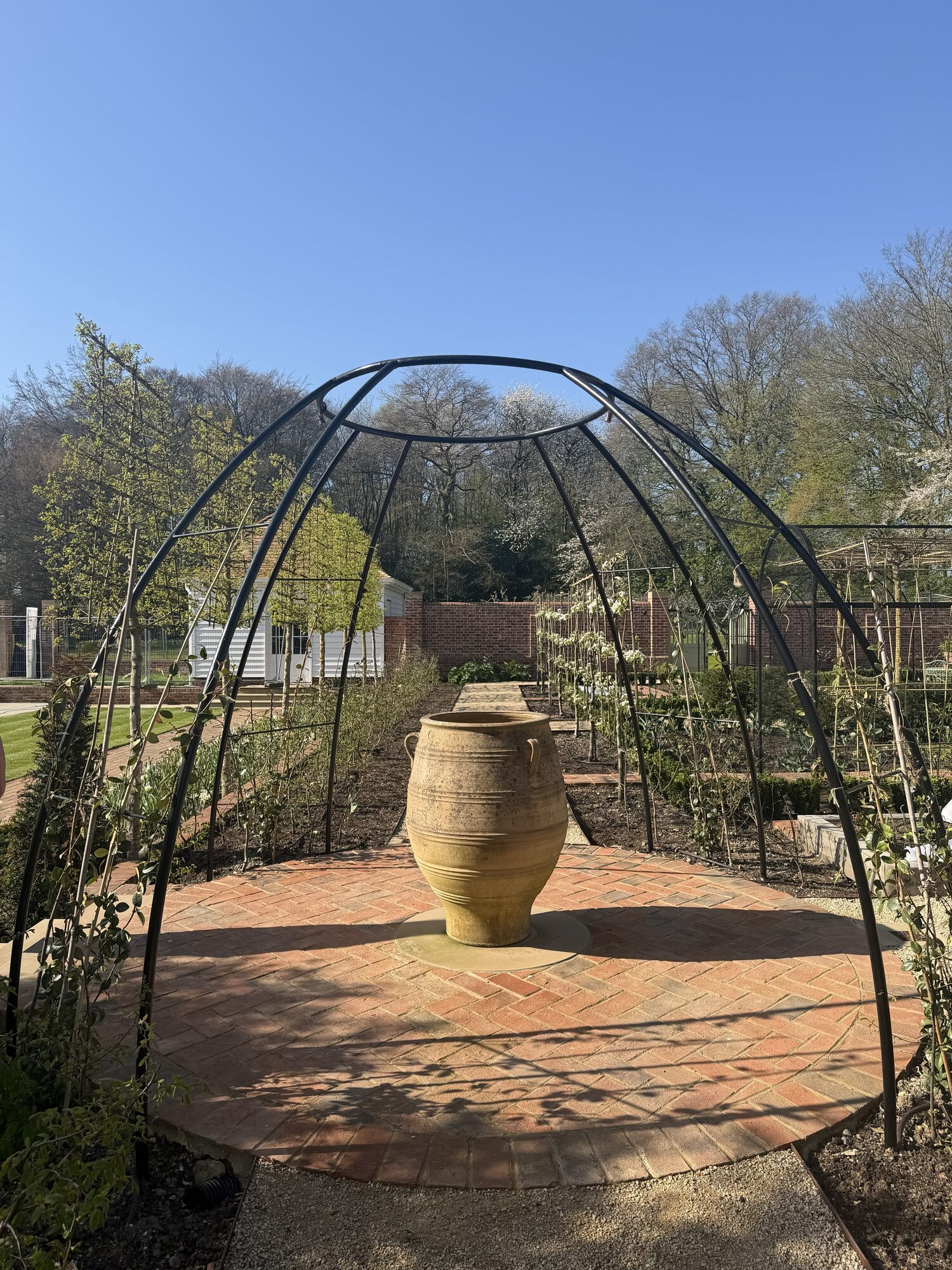 Dome-form metal pergola structure over a brick patio