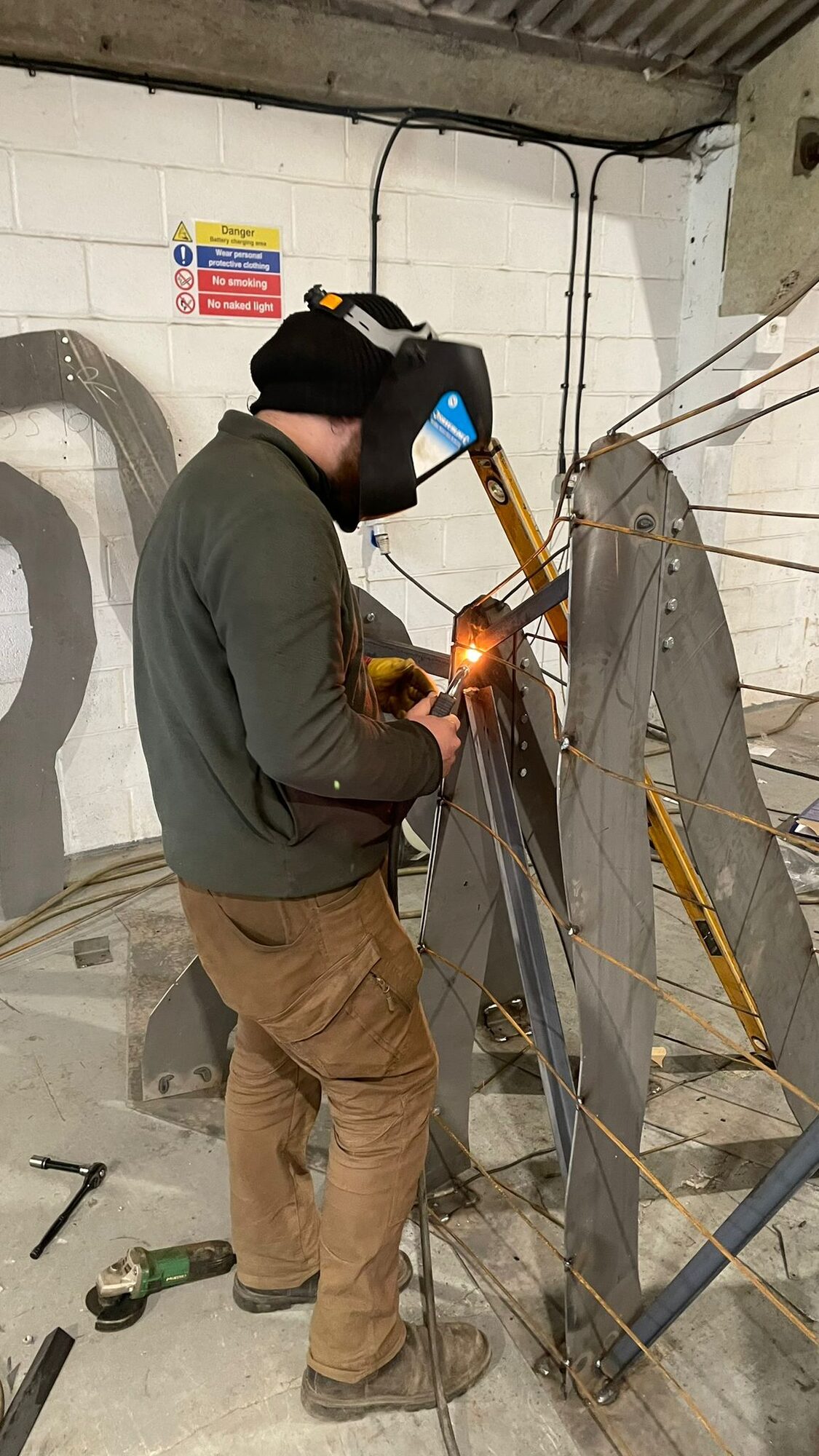 Welder working on steel section in the Lordran Forge workshop